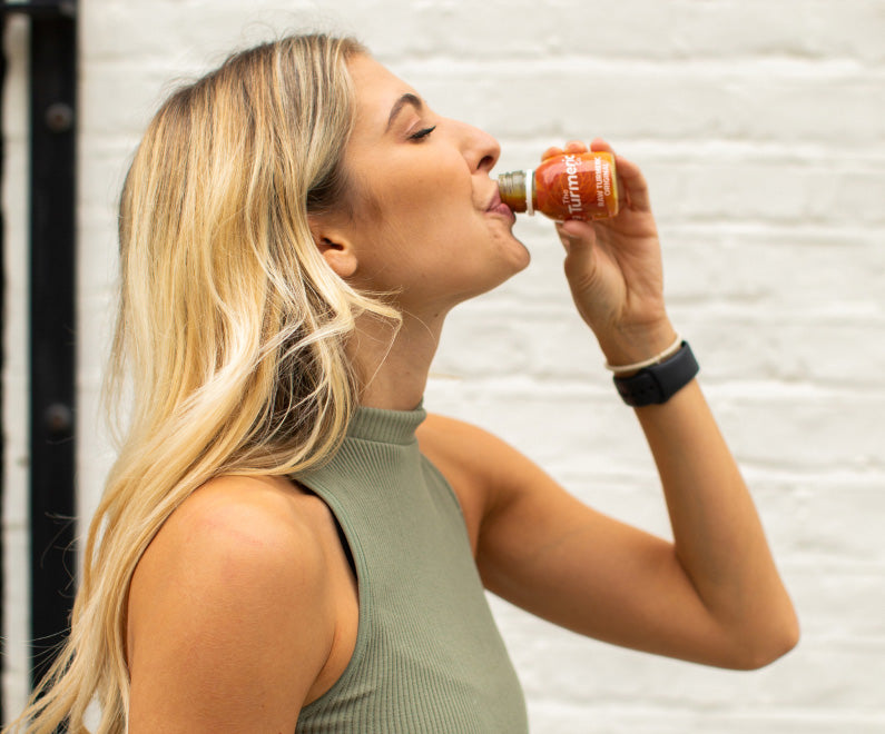 Woman drinks turmeric shot